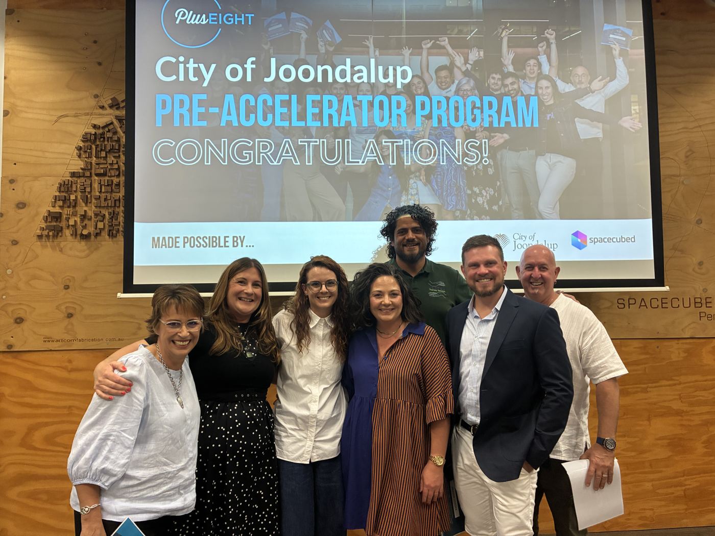 Victoria with the Plus Eight City of Joondalup Pre-Accelerator team in front of a Congratulations slide